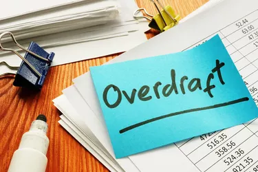 Overdraft sign and stack of accounting documents.