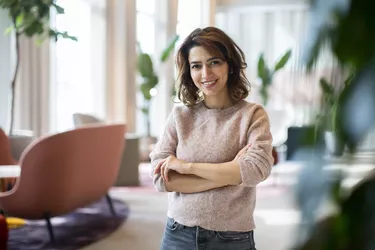 Portrait of smiling female entrepreneur standing at workplace