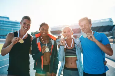 Group of athletes with gold medals looking happy