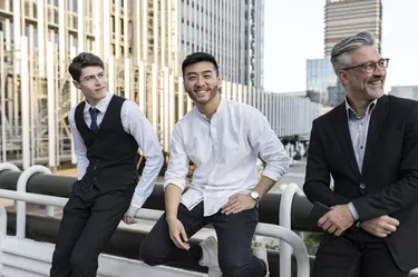 business colleagues, multiracial, sitting on railing outdoors, chatting after work among colleagues,