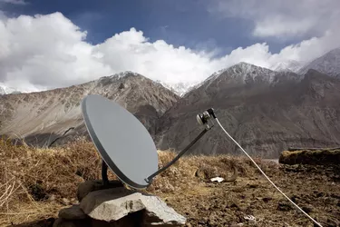 Satellite tv dish in front of snowy mountains