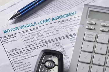 Automobile lease agreement document with key and pen on contract