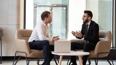 Middle eastern and caucasian ethnicity businessmen talking negotiating indoors