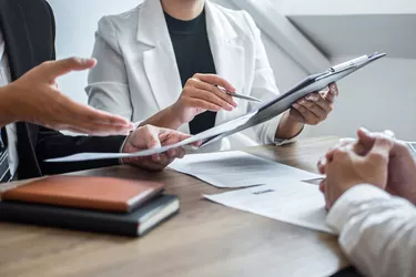 Midsection Of Business People Interviewing Man In Office