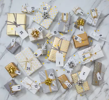 Many gift boxes with labels numbers for Advent calendar wrapped in glossy classical pack ready for celebrating holiday