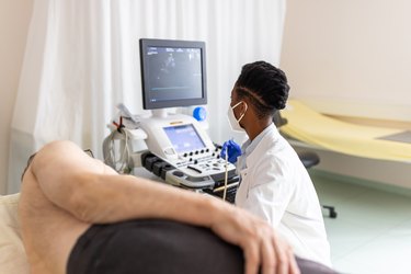 Cardiologist performing echocardiography of a senior patient