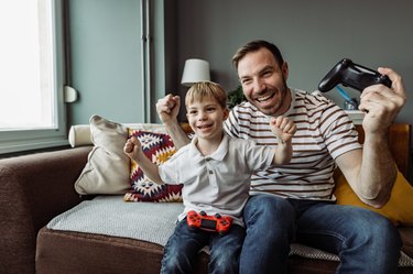 Young boy playing video games with his father