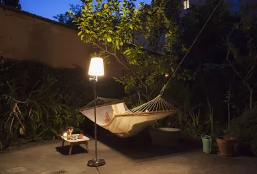 Woman reading in the hammock in garden at night