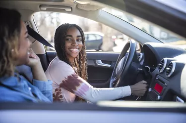 Mother handing car keys to teenage daughter