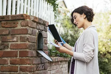 Side view of beautiful young woman at mailbox