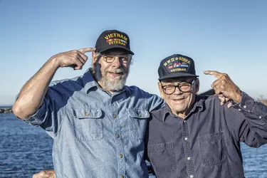 Two USA Military War Veterans Pointing At Souvenir Hats