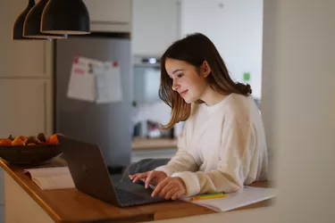 A teen girl attending online school classes from home