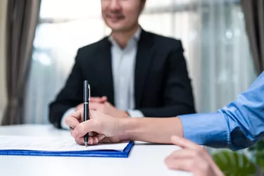 Close up hands of businesswoman sign contract agreement on paper with pen after negotiation for Business deal and acquisition. Investor girl consult with Salesman banker for loan insurance investment.