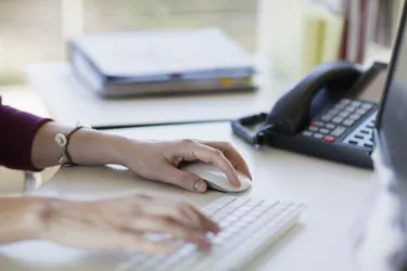 Hands of woman using computer keyboard and mouse