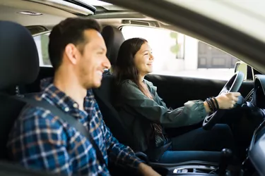 Good-looking dad and teenage girl driving together