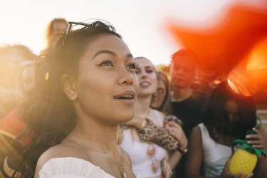 Smiling woman in crowd enjoying at music festival