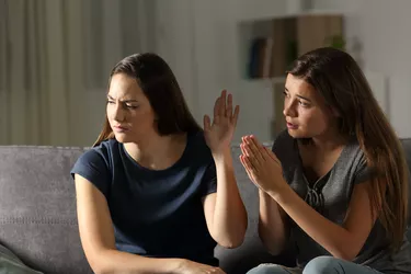 Woman begging forgiveness and friend ignoring her