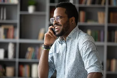 African businessman holding mobile phone enjoy informal conversation