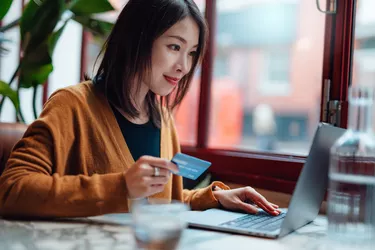 Young Beautiful Woman Shopping Online On Laptop In A Restaurant