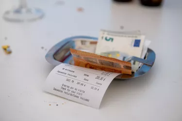 Restaurant receipt in a small tray with euros