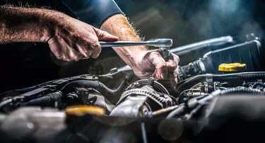 Auto mechanic working on car engine in mechanics garage. Repair service. authentic close-up shot