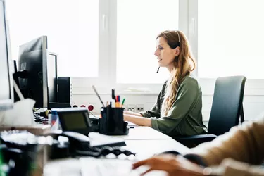 Woman Busy At Work Talking To Customers On The Phone