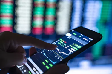 Close-up of hands of businesswoman analyzing stock market charts and key performance indicators