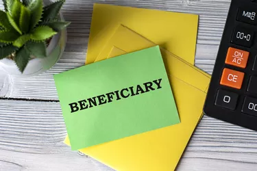 BENEFICIARY - words on green paper on the background of a calculator, and a cactus