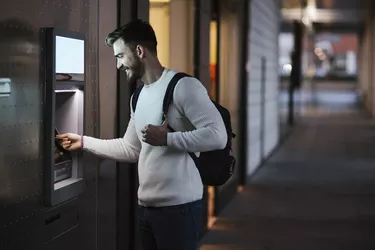 Man withdrawing money at an ATM in the city