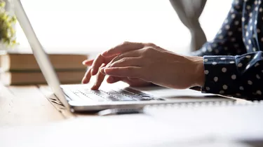 Female professional student using laptop at desk, close up view