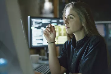 Woman monitors dark office