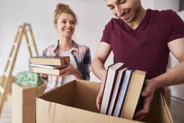 Young couple packing books into box