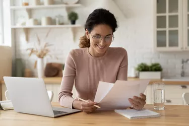 Happy millennial hispanic lady review printed paper documents financial reports