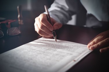 Notary signing a contract with fountain pen