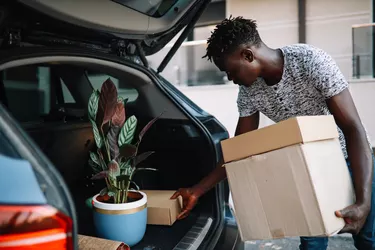 Young man taking stuff from the car to their new apartment