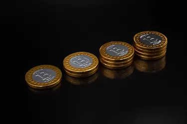Stack of physical bitcoin crypto currency coins on an isolated black background