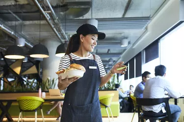 young waitress delivers food in restaurant