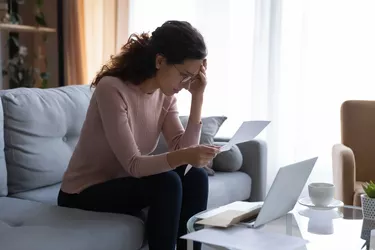 Woman with laptop reading document