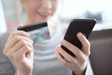 Woman using mobile phone shopping online with credit card