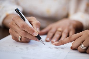 Shot of a woman going over paperwork with her elderly mother at home