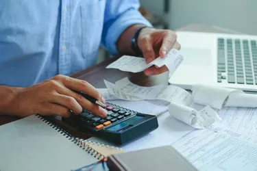 Stressed young man holding pen working on calculator to calculate business data, taxes, bills payment, Start up counting finance.accounting, statistics, and analytic research concept