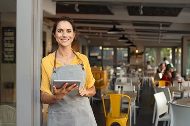 Small business owner at entrance looking at camera