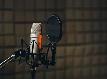 Pan shot of a professional microphone for dubbing and voice over in the sound recording studio. Close up, podcasting concept