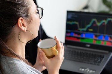 Woman looking at trading charts on her laptop