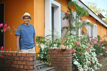 Portrait of a Man standing outside a beautiful house