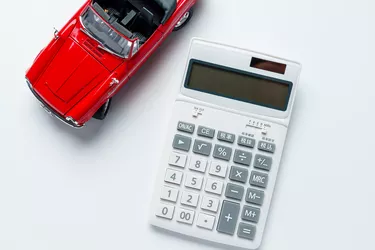 Calculator and sports car isolated on white background