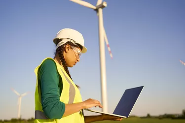 Female engineer setting up wind turbine.
