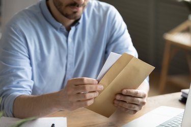 Close up of man open envelope with letter