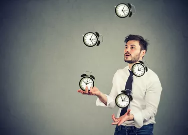 business man juggling his time alarm clocks