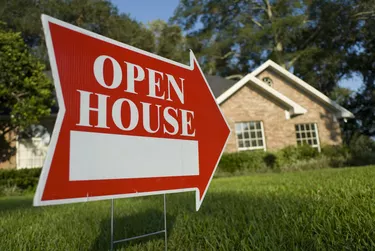 Red Open House sign pointing at house for inspection